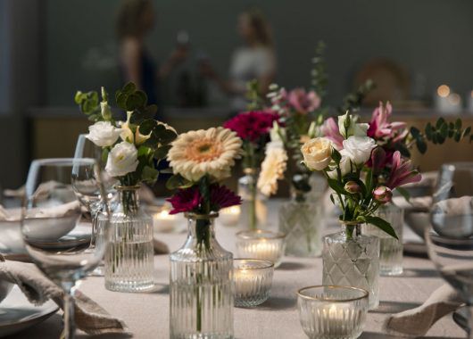 festbord pyntet med blomster i småvaser festbord pyntet med blomster i småvaser