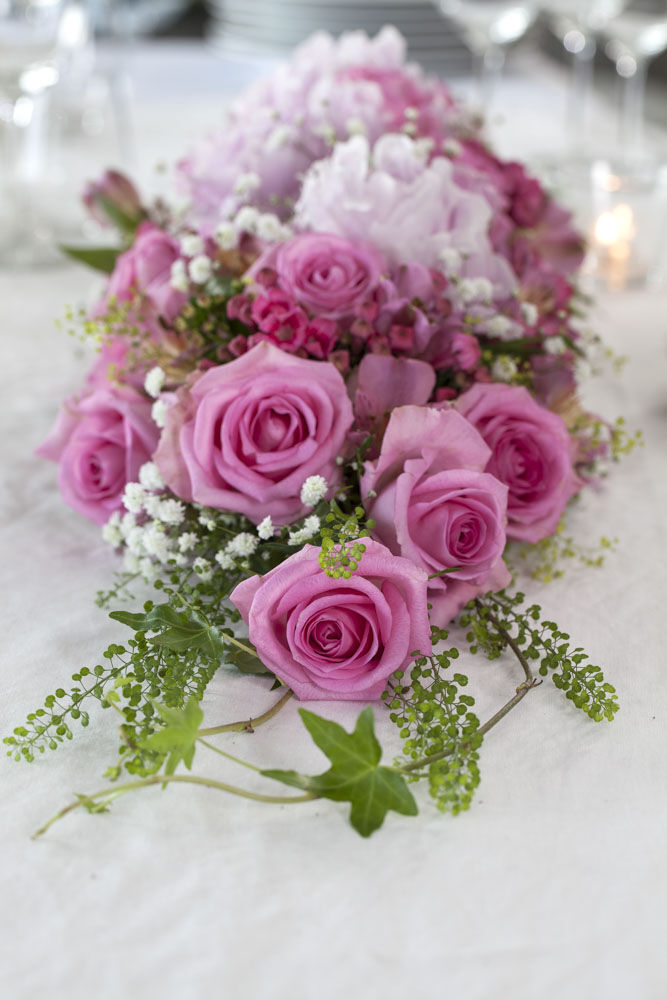borddekorasjon med rosa roser på festbordet 