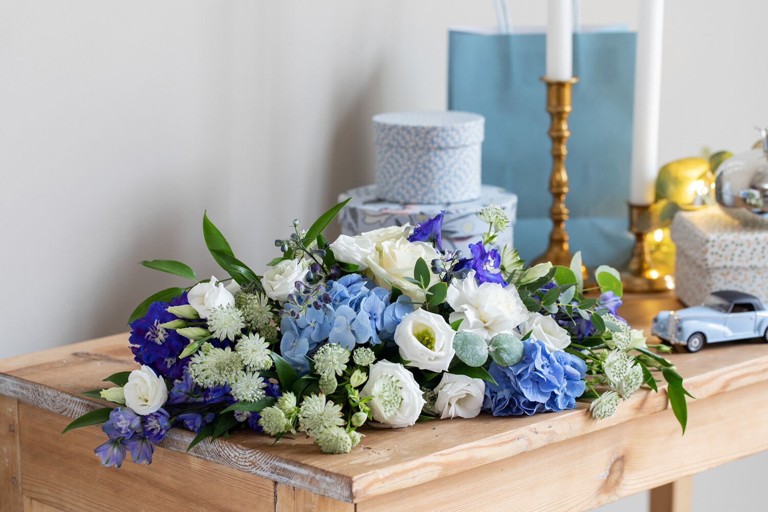 borddekorasjon med blå hortensia og aprikos roser