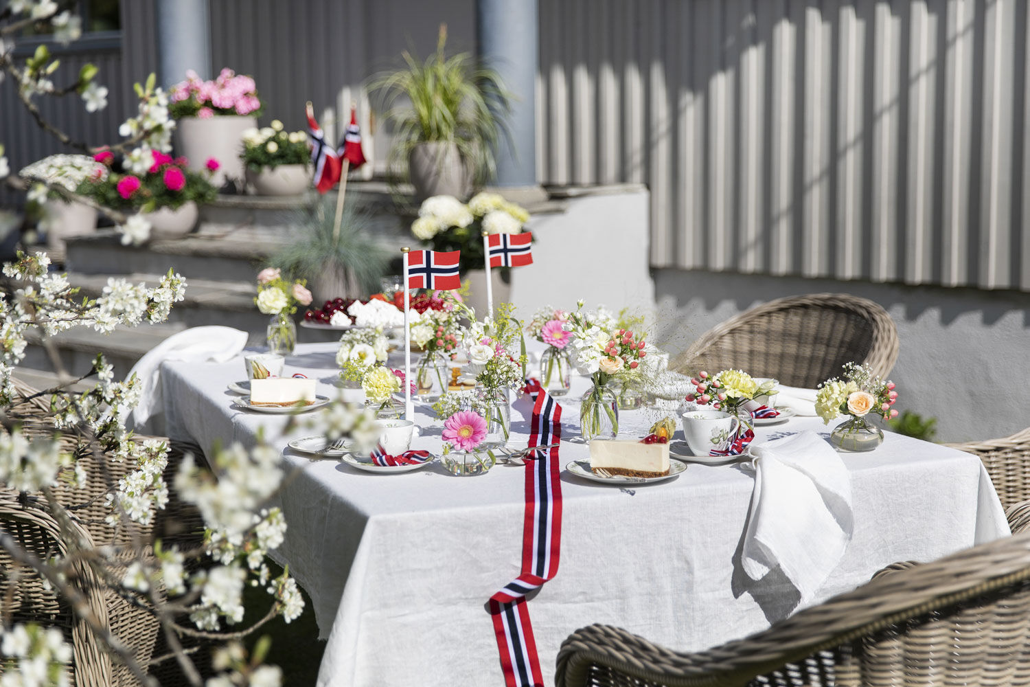 Pynt 17. mai-bordet med små vaser med blomster i nasjonalfargene