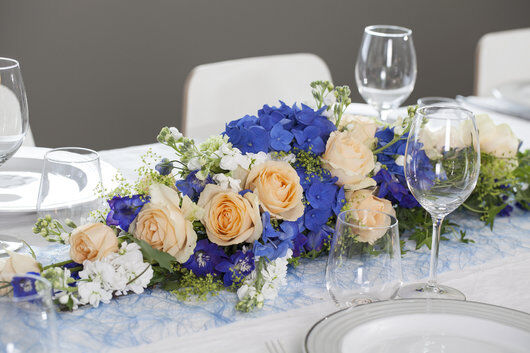 borddekorasjon med blå hortensia og aprikos roser
