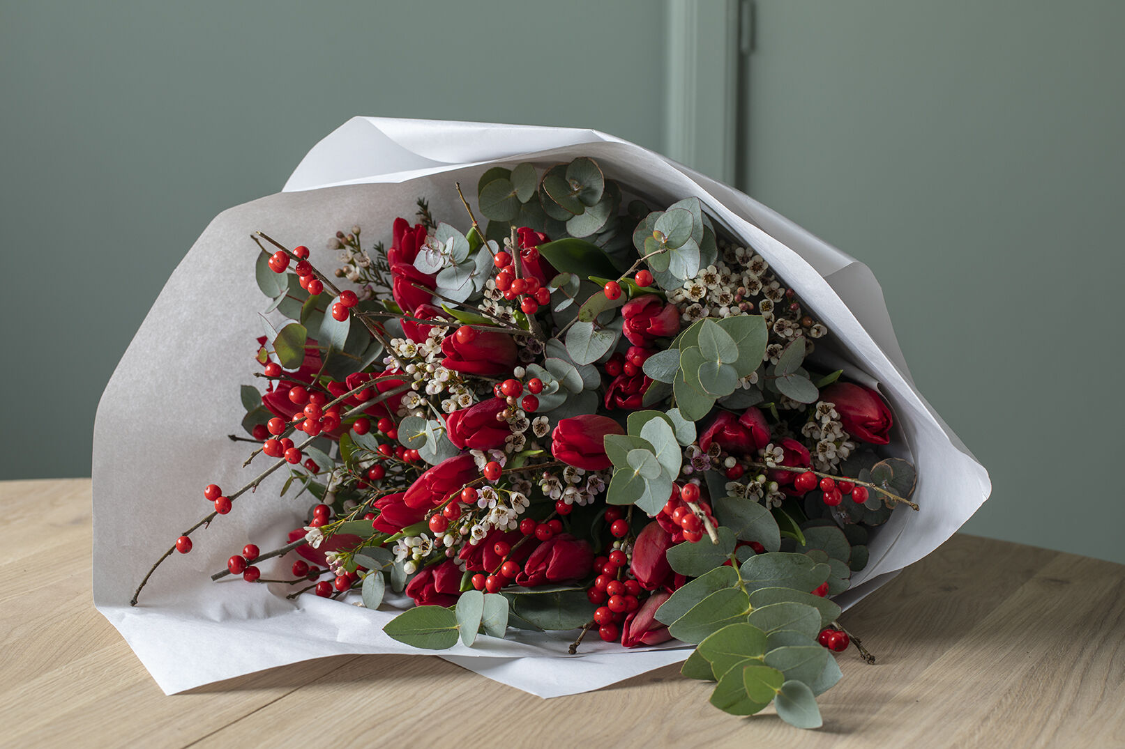 Røde tulipaner med grener i vase Røde tulipaner med grener i vase