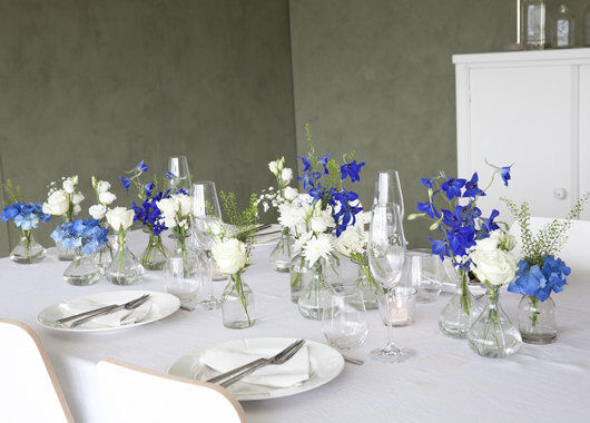 pyntet bord med blå og hvite blomster i små Dalebekken vaser
